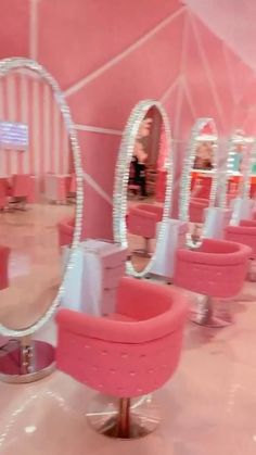 pink chairs and mirrors in a room that looks like it is being used as a hair salon