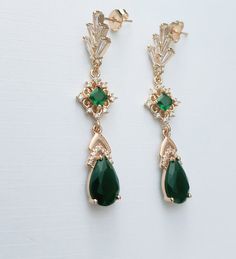 **All orders come with free tracked shipping** High quality champagne gold plated Gatsby style earrings with emerald and clear cubic zirconia stones.  There are 2 jewelry box options: Box A: regular jewelry cardboard box with a textured diamond pattern on the outside (comes in white, black or red) Box B: Velvet earring and necklace box (comes in green, red and grey) You can also add a mini gift bag as show in the pics: comes with green, red or grey satin ribbon and a few sheets of gift tissue pa Art Deco Gold Dangle Bridal Earrings, Gold Art Deco Dangle Bridal Earrings, Art Deco Gold Drop Bridal Earrings, Gold Art Deco Drop Bridal Earrings, Vintage Emerald Drop Earrings, Art Deco Green Jewelry For Pierced Ears, Victorian Green Earrings For Wedding, Gold Art Deco Bridal Earrings Gift, Gold Art Deco Bridal Earrings For Gift