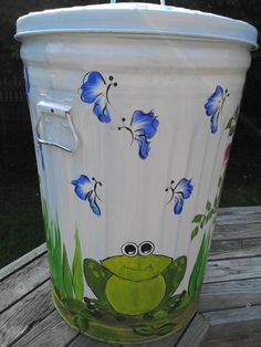 a painted trash can sitting on top of a wooden table