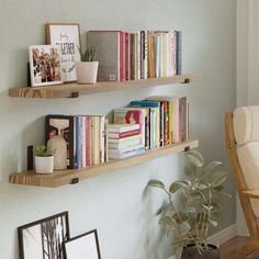 two wooden shelves filled with books next to a chair