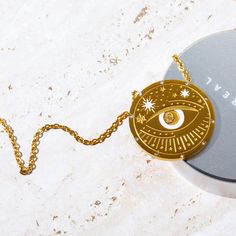 Our Celestial Coin Medallion Necklace—a captivating accessory inspired by the celestial wonders of the universe. This necklace features a stunning coin-shaped pendant crafted in gold, adorned with celestial motifs that evoke a sense of mystery and magic. With three distinct styles to choose from—moon phase, sun and moon, and evil eye—this necklace allows you to express your unique style while embracing the celestial energies that surround us. Celestial Round Medallion Necklace For Gifts, Mystical Gold Engraved Necklace, Mystical Engraved Gold Necklace, Celestial Medallion Necklace Gift With Round Pendant, Mystical Gold Charm Necklace Gift, Gold Mystical Necklace With Sun And Moon Design, Mystical Gold Necklace With Sun And Moon Design, Mystical Gold Round Pendant Jewelry, Gold Necklace With Sun And Moon Design