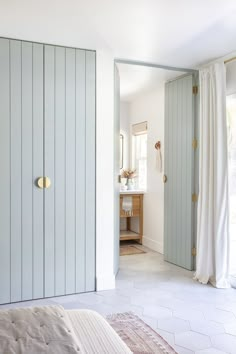 a bedroom with white walls and light blue closets in the corner, along with a rug on the floor