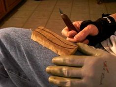 a person wearing gloves and holding a knife in one hand while sitting on the floor