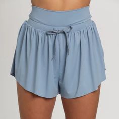 Best Selling Go-With-The-Flow Athletic Shorts Are Designed To Be Totally Versatile. The Smooth, Cool Athletic Material Can Handle Any Workout Or Is Comfortable For Everyday Wear. These Shorts Feature A Flowy, Butterfly Side Cut Design And A High Waisted Drawstring Waist Band. They Are Complete With Built-In Spandex Shorts With Side Pockets For Functionality. Spandex Lined Shorts Comfort Waist Band Drawstring Waist Tie Hidden Side Pockets Machine Wash Cold Wash With Like Colors Tumble Low Dry Do Workout Shorts With Pockets, Blue Stretch Summer Activewear, High Waist Sports Bottoms For Summer, Versatile Blue Workout Bottoms, Versatile Blue Bottoms For Workout, Summer High-waisted Sports Shorts, Versatile Athletic Shorts For Yoga In Summer, Light Blue Bottoms With Built-in Shorts And Relaxed Fit, Blue Athleisure Bottoms With Built-in Shorts