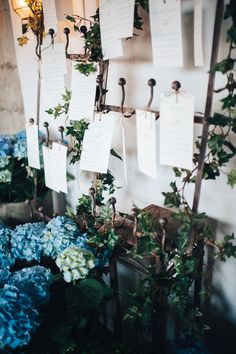 blue and white flowers are on display with notes pinned to the wall