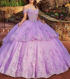 a woman in a purple ball gown posing for the camera