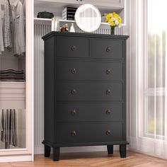 a black dresser in a white closet with yellow flowers