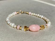 PINK OPAL BRACELET HANDMADE WITH FRESHWATER PEARLS AND GOLD FILLED Freshwater Pearl bracelet with Pink Opal, Aquamarine, Citrine and Gold filled beads. This bracelet comes in a length of 17,5cm.  If you need another length, please let me know when you order. Here you can find all my other bracelets: https://www.etsy.com/de/shop/ilkajewels?ref=seller-platform-mcnav&section_id=24365956 I send all my jewelry pieces nicely packed in a jewelry bag. MATERIAL -freshwater pearl, 4mm -Gold filled beads a Handmade Spiritual Pearl Bracelet As Gift, Dainty Pearl Bracelet With Natural Stones As Gift, Dainty Pearl Bracelet With Natural Stones, Dainty Natural Stone Pearl Bracelet Gift, Spiritual Pink Jewelry For Birthday, Hand-strung Rondelle Pearl Bracelet Gift, Hand-strung Pearl Bracelet Gift, Pearl Bracelet With Natural Round Beads, Natural Stone Pearl Bracelet With Round Beads