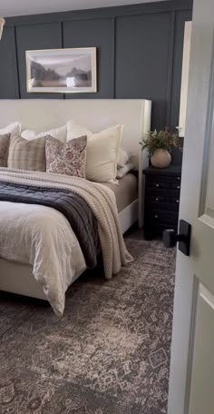 a bedroom with a bed, dresser and pictures hanging on the wall above it's headboard