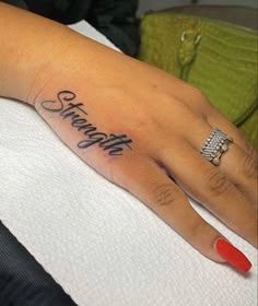 a woman's hand with the word strength tattooed on it