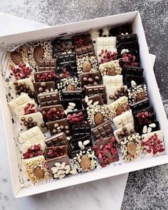 a white box filled with lots of different types of chocolates and candies on top of a table