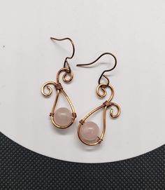 These earrings were made from copper wire and feature a genuine rose quartz stone bead in the center. The earring hooks are nickel free and copper colored to match. Rose Gold Wire Wrapped Copper Wire Earrings, Adjustable Wire Wrapped Rose Gold Earrings, Rose Gold Wire Wrapped Earrings In Copper, Adjustable Rose Gold Wire Wrapped Earrings, Rose Gold Wire Wrapped Earrings, Nickel Free Rose Gold Copper Wire Earrings, Nickel-free Rose Gold Copper Wire Earrings, Rose Quartz Earrings, Rose Quartz Stone