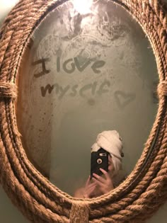 a person taking a selfie in front of a rope mirror