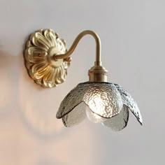 a wall light that is on the side of a wall next to a lamp shade