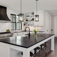 a large kitchen with an island and black counter tops