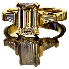 Dekara Design Collection Metal-18K Yellow Gold, 18K White Gold, .750. Stones- Center GIA Certified Emerald Cut Diamond J Color VS1 Clarity 1.62 Carats, Two Sides Baguette Diamonds H-I Color VS1-VS2 Clarity 0.40 Carats. GIA Report # 1353255620 Size- 6 3/4. FREE SIZING!!!! 18K Yellow Gold Emerald Cut Diamond Engagement Ring Handmade By DeKara Designs. Art Deco inspired, Extremely Brilliant, Entirely Handmade, Beautiful Emerald Cut Diamond Engagement Three Stone Ring Made in 18K Yellow Gold. The ce Luxury Gold Emerald Ring For Formal Occasions, Gold Emerald Diamond Ring With Baguette Cut, Luxury Yellow Gold Emerald Ring With Diamond, Gold Emerald Cut Hallmarked Emerald Ring, Elegant Yellow Gold Diamond Ring Gia Certified, Exquisite Gold Emerald Ring For Anniversary, Elegant Gia Certified Yellow Gold Diamond Ring, Dazzling Yellow Gold Rings, Timeless Emerald Ring With Diamond In Gold Setting