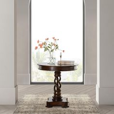 a vase with flowers sitting on top of a table next to an open window in a room