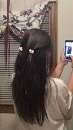 a woman is taking a selfie in front of a mirror with her hair styled into a pony tail