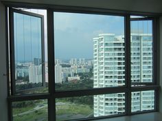 an empty room with large windows looking out at the city below it and buildings in the distance