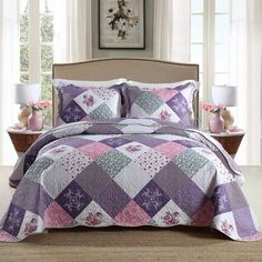 a bed covered in a purple and white quilt