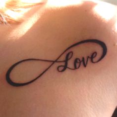 a woman's back with the word love written in cursive font on it