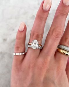 a woman's hand with three different rings on it and one ring in the middle