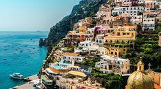 an aerial view of some buildings on the side of a hill next to the ocean