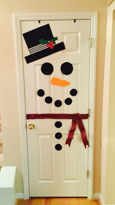 a door decorated with a snowman's hat and scarf