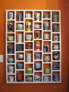 a white shelf filled with lots of cups