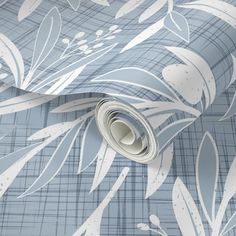 a blue and white wallpaper with leaves on it's side, next to a roll of toilet paper