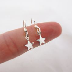 SOLID STERLING SILVER EARRINGS These celestial earrings make a wonderful gift. The real sterling silver ear hooks are adorned with a tiny star (also 925 sterling silver). Comes in a gift box, perfect for gift giving. Total earring length is just under 1 inch long.  STAR CHARM: Please note that the star charms are TINY. Their dainty size measures approximately 1/4 inch tall.  ALSO AVAILABLE IN A MOON DESIGN OR MOON/STAR COMBO Silver Sterling Hoop Earrings With Star Charm, Dainty Sterling Silver Hoop Earrings With Star Charm, Sterling Silver Hoop Earrings With Star Charm For Gift, Minimalist Sterling Silver Star Charm Earrings, Dainty Sterling Silver Star Hoop Earrings, Nickel-free Sterling Silver Star Hoop Earrings, Silver Dainty Star Charm Earrings, Silver Hoop Earrings With Star Charm As Gift, Silver Dainty Earrings With Star Charm