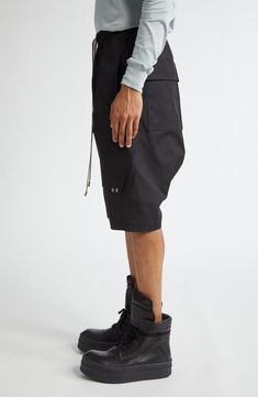 Angluar cargo pockets bring signature Rick Owens edge to these stretchy cotton cargo shorts. 36" inseam; 32" leg opening; 13 1/2" front rise; 17 1/2" back rise (size 50EU) Elastic/drawstring waist Cargo bellows pockets 97% cotton, 3% elastane Hand wash, line dry Made in Italy Designer Clothing Cargo Shorts Men, Mens Cargo, Bellows, Nordstrom Store, Anniversary Sale, Black Fits, Rick Owens, Black Shorts, Cargo Shorts