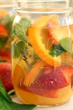 mason jar filled with fresh fruit and mint leaves