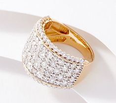 a gold and diamond ring sitting on top of a white surface