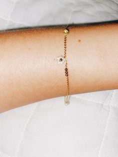 + DAISY CHAIN FRIENDSHIP BRACELET +Tiny Natural Pearls surround a 14ky Gold-filled bead to make this daisy chain bracelet along with a three 2mm 14ky gold-filled beads, a pearl, and Peridot rondelle or you can keep it simple with just one daisy beads in center. Its a melody of stones and pearls along your wrist. A perfect and sweet bracelet that is an upscale friendship bracelet. The pearls are Natural fresh water pearls that should not be exposed to water or liquids. Tiny Ball beads and chain a Dainty Jewelry With Adjustable Flower Charm, Friendship Bracelet With Flower Charm, Dainty Adjustable Flower Chain Bracelet, Dainty Adjustable Bracelet With Flower Charm, Adjustable Gold Pearl Flower Bracelet, Flower Charm Bracelet For Friendship, Flower Charm Bracelet Jewelry For Friendship, Dainty Gold Flower Pearl Bracelet, Dainty Yellow Gold Bracelet With Flower Charm