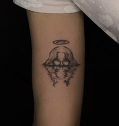 a woman's arm with a tattoo on it and an angel above her head