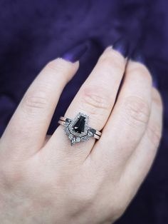 a woman's hand with two rings on it and an engagement ring in the middle