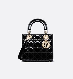 The Lady Dior bag epitomizes Dior's vision of elegance and beauty. Sleek and refined, the timeless style is crafted in black patent calfskin with Cannage stitching, creating the instantly recognizable quilted texture. Pale gold-finish metal D.I.O.R. charms further embellish its silhouette. The small Lady Dior bag features a thin, removable leather shoulder strap and can be carried by hand or worn crossbody.. Dior Lady Dior Bag, Dior Mini Bag, Lady Dior Mini, Mini Lady Dior, Lady Dior Handbag, Small Lady, Christian Dior Couture, Luxury Purses, Dior Handbags