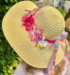 "Who's ready for the beach?  Do you have all the appropriate beach gear you'll need when summer rolls around?  How about a fun beach hat, more specifically, a fun beach hat that reminds you of being at a tropical island?  This woven straw sun hats has a wide, floppy brim and 22\" circumference to fit nearly all adults.  The sun hat is breathable and keeps the sun's glare at bay, making it perfectly comfortable to wear outdoors in the summer, gardening or hosting backyard parties. Use the floppy sun hat as table decor that guests can take with them!  Relax in style this summer by protecting your skin and looking fabulous.  An orchid-print and rainbow lace ribbons, bow and tropical orchids adding a wonderful touch! Start getting yourself beach ready with this adult floppy beach hat!" Tropical Hat, Hosting Backyard, Straw Hats Outfit, Hat Outfit Summer, Lee Sin, Summer Gardening, Orchid Print, Backyard Parties, Rainbow Laces