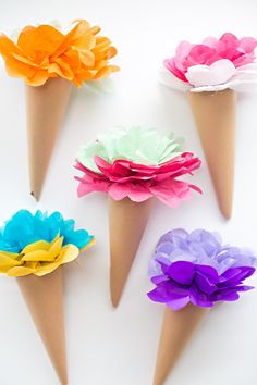 six ice cream cones with colorful paper flowers in them