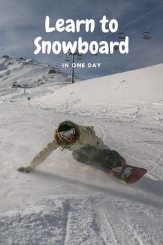 a person riding a snowboard down a snow covered slope with the words learn to snowboard in one day