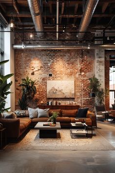 an industrial living room with exposed ceilings and brick walls, leather couches, coffee table, potted plants and large windows