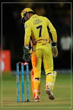 a man in yellow uniform playing a game of cricket