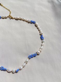 Pearl necklace with blue flowers Blue Beaded Necklaces With Pearl Pendant, Blue Beaded Necklace With Pearl Pendant, Blue Pearl Necklace With Colorful Beads For Gift, Blue Flower-shaped Jewelry With Beaded Chain, Blue Pearl Necklace With Round Beads Pendant, Elegant Blue Pearl Necklace With Colorful Beads, Blue Flower Necklace, Blue Beaded Pearl Necklaces With Pearl Pendant, Blue Single Strand Pearl Necklace Gift