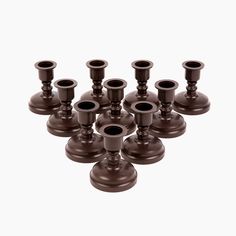 twelve brown candlesticks are arranged in the shape of an eight - sided candle