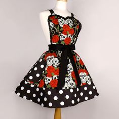 a dress with skulls and roses on it is sitting on a mannequin head