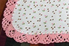 a crocheted doily with pink flowers on it