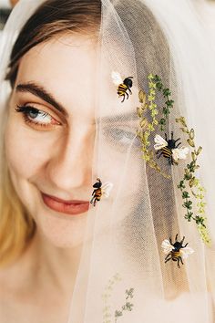 a woman wearing a veil with bees on it