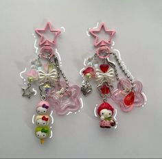 two hello kitty key chains with charms attached to them