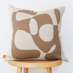 a brown and white pillow sitting on top of a wooden chair